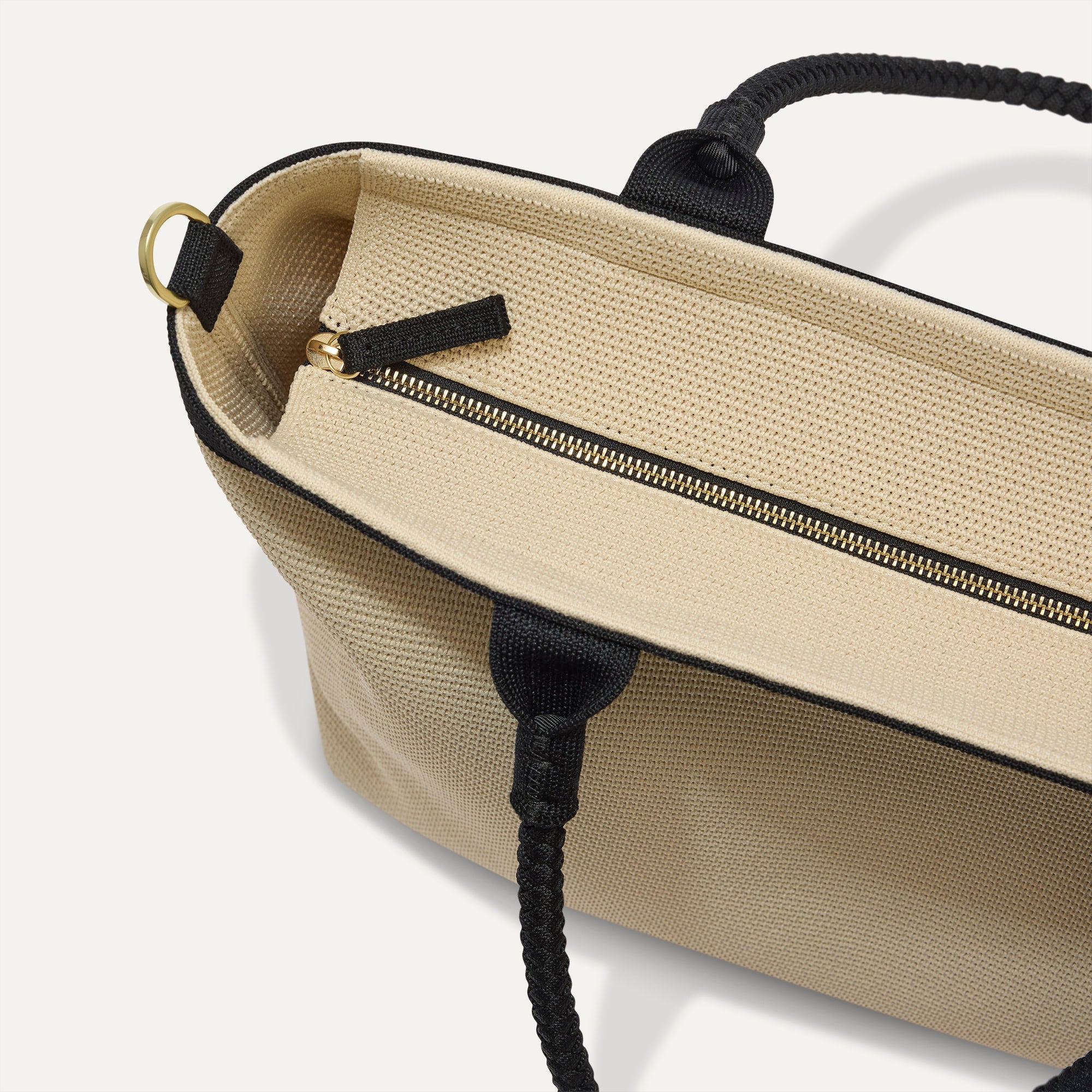 The Lightweight Zip Tote in Black and White Raffia-Knit, focusing on the zip closure and handles.