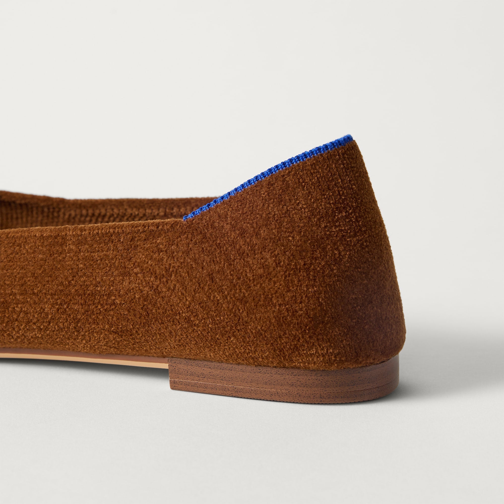 Close up of the heel of The Point III in ReVelvet Russet, with Rothy's signature blue halo. 